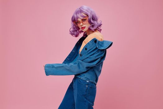 Positive young woman purple hair fashion glasses denim clothing color background unaltered. High quality photo