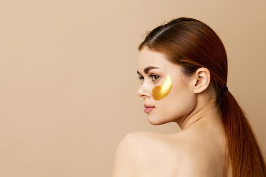 young woman skin care face patches bare shoulders hygiene isolated background. High quality photo