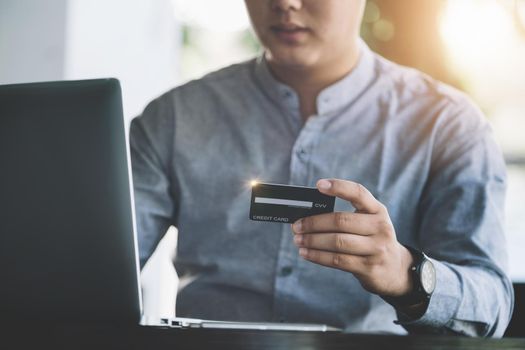 Online Shopping and Internet Payments, Asian man are using their credit card and computer laptop to shop online or conduct errands in the digital world