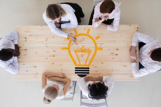 High angle view of business people at meeting table. Conceptual for bright business ideas and innovations.