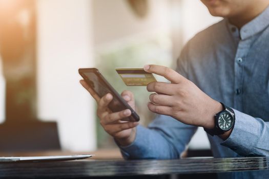 Online Shopping and Internet Payments, Asian man are using their credit card and mobile phone to shop online or conduct errands in the digital world