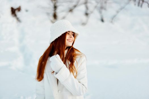 pretty woman in a white coat in a hat winter landscape walk Fresh air. High quality photo