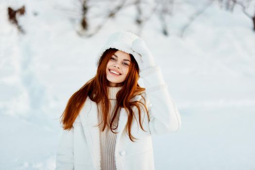 beautiful woman in a white coat in a hat winter landscape walk Lifestyle. High quality photo