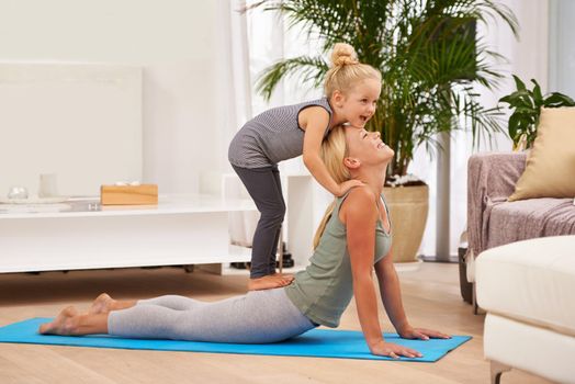 Full length shot of a mother and daughter doing yoga together.