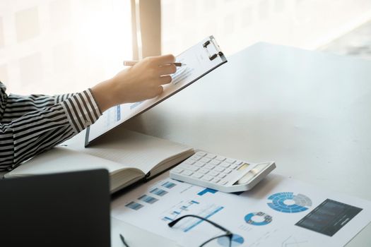 Business accounting concept, Business Man using calculator with computer laptop, pen, budget and loan paper in office.