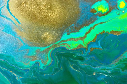 Gold spots on flow blue and green wave paints abstract background.