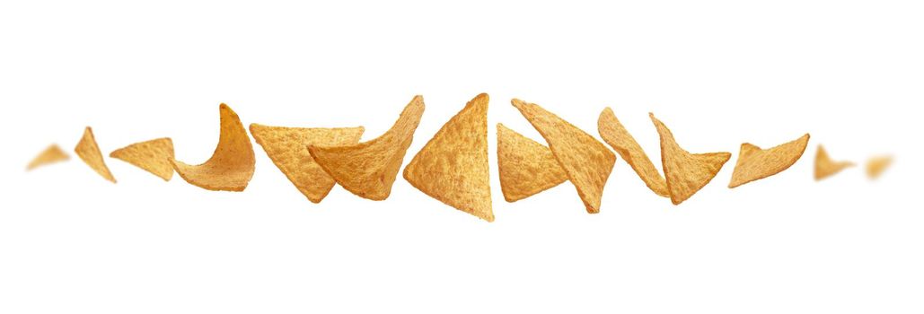 Corn chips of triangular shape levitate on a white background.