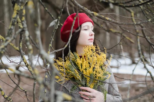 beautiful portrait of a young woman with mimosa flowers outdoors