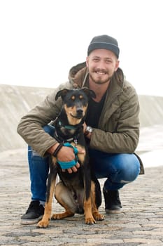 Portrait of a young man and his dog spending time together outdoors.