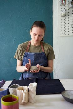 Woman making ceramic pot on workshop. Concept for woman in freelance, business. Handcraft product. Earn extra money, side hustle, turning hobbies into job.