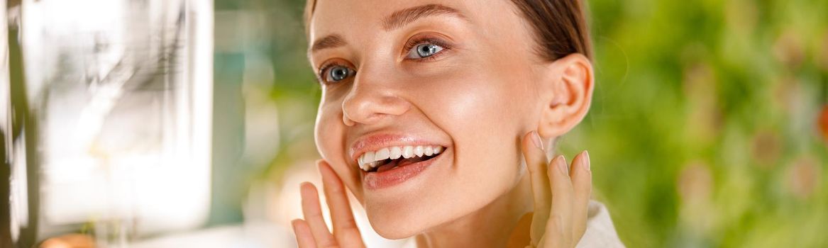 Closeup portrait of gorgeous young woman with smooth skin smiling while having beauty routine in the bathroom. Spa and wellness concept