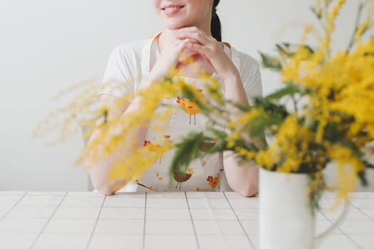 Beautiful young smiling woman with mimosa flowers on white background.