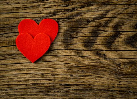 two bright red hearts on dark vintage texture old wood background, symbol of Valentine's day, copy space for text, top view.