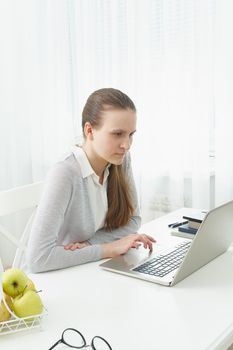 Distance education for students. Quarantine, self-isolation, sociophobia. Young girl listens to online learning, teleworking, online lectures.Woman look at laptop. Freelancer, Digital Nomad Concept