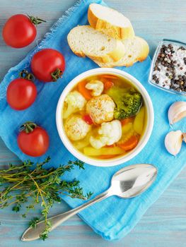 Delicious, thick Soup with Turkey meatballs and mixed vegetables - cauliflower, broccoli, carrots, potatoes, garlic, tomatoes. Copy space, top view