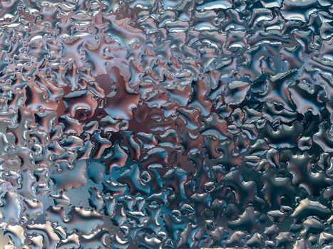 Abstract gray background with large and small convex drops of water on glass, condensation on window. Macro, close up.