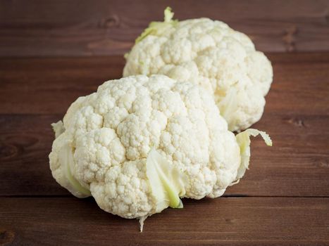 two ripe fresh red cauliflower on wooden brown background