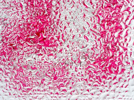 Abstract pink and white background with large and small convex drops of water on glass, condensation on window. Macro, close up.