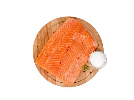 Fresh salmon fillet on wooden cutting board on white background, top view