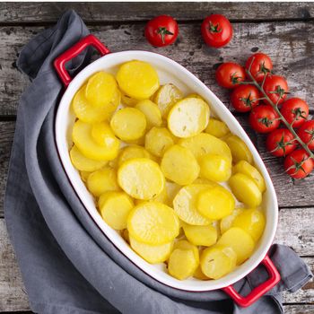 Baked slice of potatos, a healthy diet food. Dark old wooden rustic gray background, top view