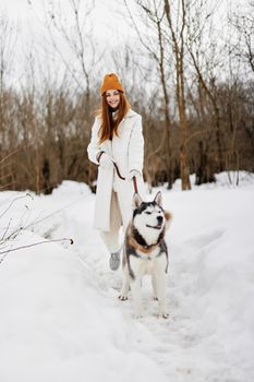 cheerful woman in the snow playing with a dog fun friendship winter holidays. High quality photo