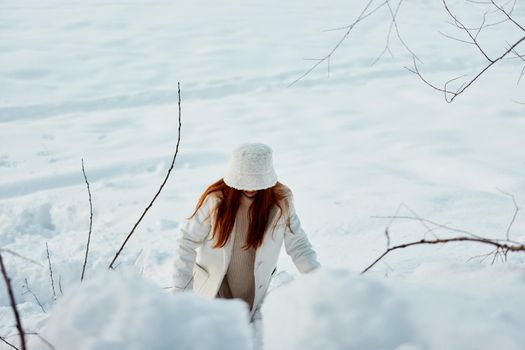 pretty woman in a white coat in a hat winter landscape walk Lifestyle. High quality photo