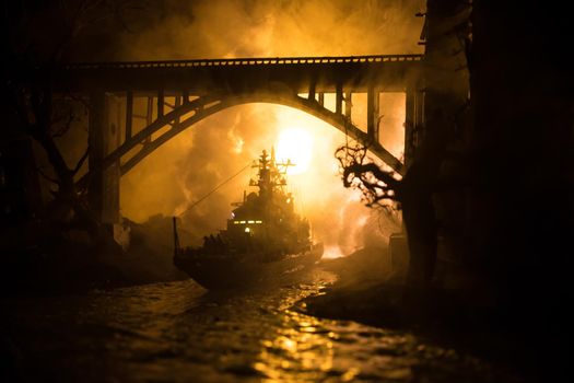 War concept. Night battle scene at sea. Dramatic toned clouds effect. Silhouette of the battle ship in night. Miniature creative table decoration. Selective focus