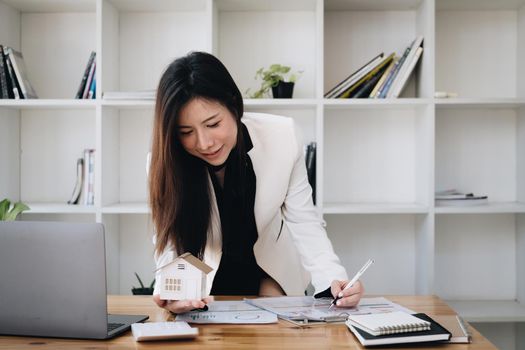 A woman holding and checking house model .Real Estate House Appraisal And Inspection and Insurance concept