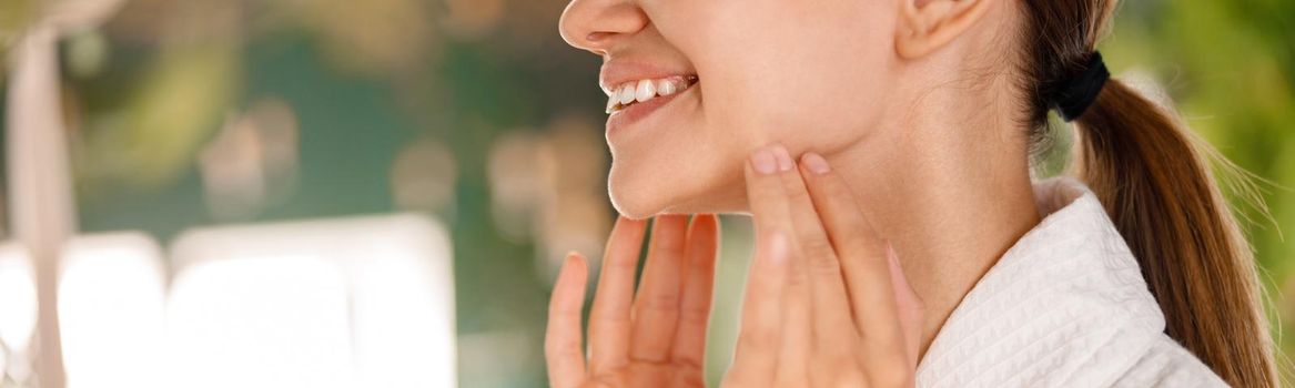 Closeup of young woman with beautiful smile and perfect skin enjoying beauty procedures, taking care of her skin. Spa and wellness concept