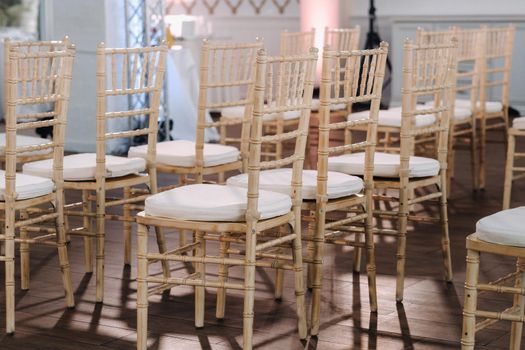 A place for a wedding ceremony in the interior with chairs. Decorated wedding venue.