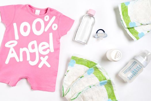 Babies goods diaper, baby powder, cream, shampoo, oil on white background with copy space. Top view or flat lay. Maternity concept