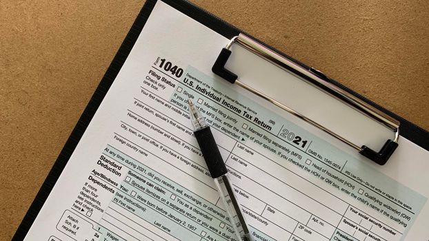 1040 tax form with pen and brown table background.