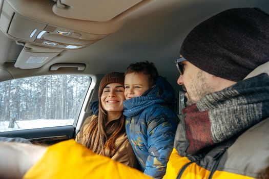 Mother, father and child traveling by car on a vacation to the mountains in winter, close up