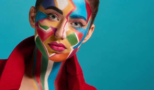 Colorful, creative and artistic pop art make up. Beautiful model looking at camera, posing. Funky and stylish woman has plump lips with pink lipstick. Blue background.
