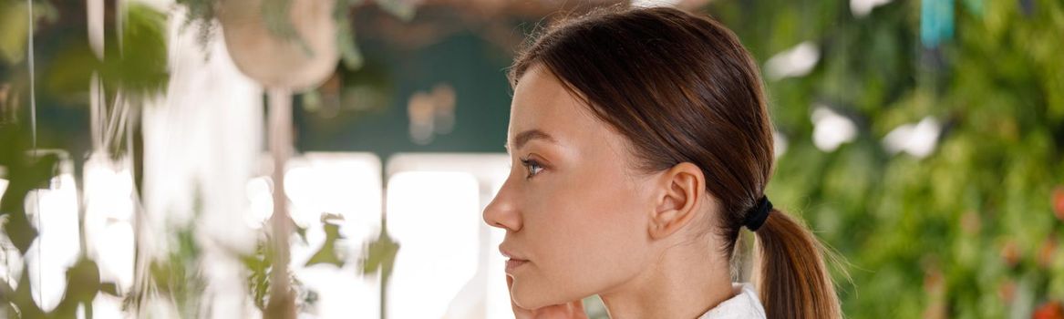 Side view portrait of pretty young woman in bathrobe enjoying beauty procedures, taking care of her skin. Spa and wellness concept