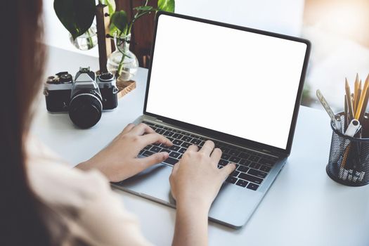 Young woman using work from home computer to avoid the risk of contracting coronavirus in the company at work, the blank space on the computer screen can insert text