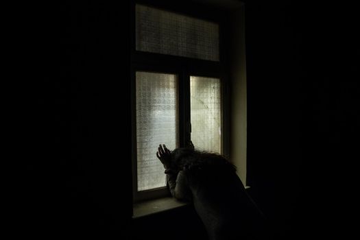 Horror silhouette inside abandoned creepy room with window at night. Horror scene. Halloween concept.