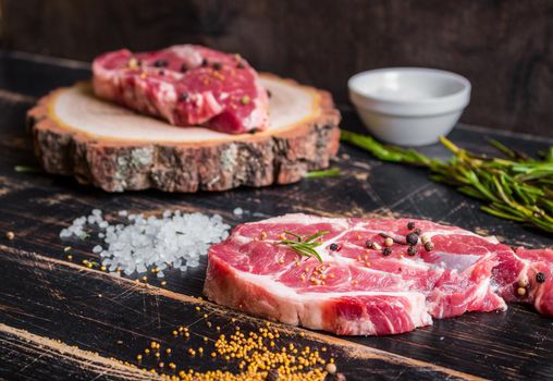 Raw meat steak on dark wooden background ready to roasting