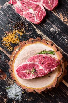 Raw meat steak on dark wooden background ready to roasting