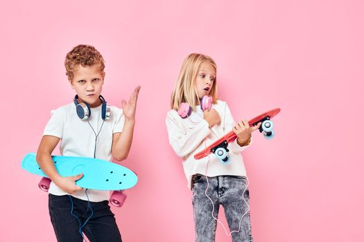 Funny children in headphones skateboards in hands active lifestyle childhood. High quality photo