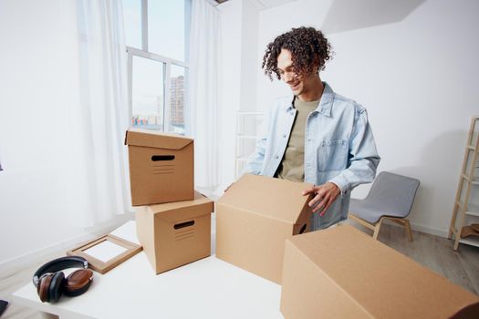 portrait of a man cardboard boxes in the room unpacking headphones interior. High quality photo