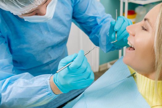 The patient treats her teeth at the dentist in the dental office . Dental fillings.