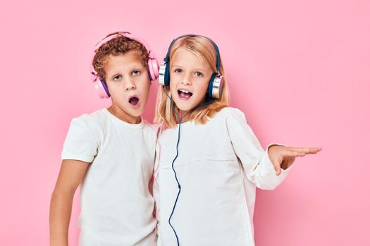 Stylish little boy and cute girl stand next to in headphones lifestyle childhood. High quality photo