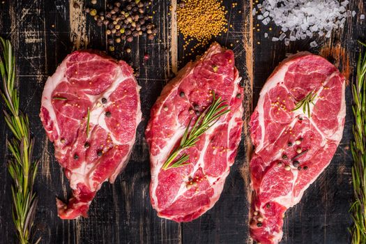 Raw juicy meat steak on dark wooden background