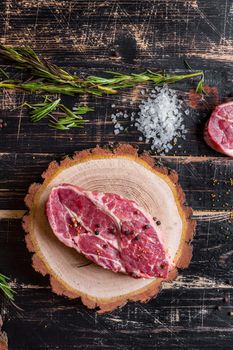 Raw meat steak on dark wooden background ready to roasting