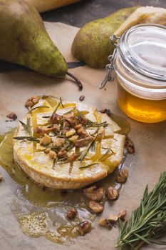 Delicious beautiful baked camembert with honey, walnuts, herbs and pears