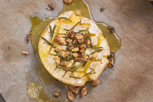 Delicious beautiful baked camembert with honey, walnuts, herbs and pears
