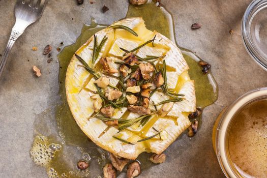 Delicious beautiful baked camembert with honey, walnuts, herbs and pears