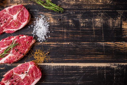 Raw juicy meat steak on dark wooden background