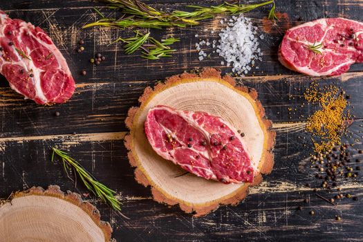 Raw meat steak on dark wooden background ready to roasting